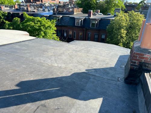 Installing rubberized roof system over tar and gravel roof system